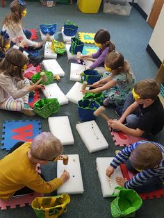 a group of children sitting on the floor playing with toys