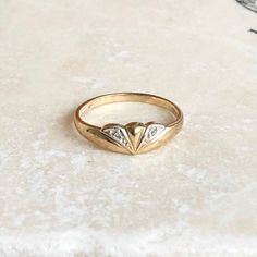 A vintage 9 carat yellow gold ring with paste stones (stones that mimic diamonds). Elegant and simple, with a wonderful shape to it. CONDITION: Good condition, wear consistent with it's age and use. Please see photos for more detail. APPROX. BAND WIDTH: 1.5mm APPROX. SETTING WIDTH: 5mm APPROX. SETTING LENGTH: 11mm RING SIZE: UK: M | US: 6 1/4 WEIGHT: 1.3g (VZZ) Vintage Diamond-cut Signet Promise Ring, Vintage Diamond Cut Signet Ring, Vintage Diamond Cut Signet Promise Ring, Classic Gold Heart Ring With Brilliant Cut, Vintage Yellow Gold Diamond Ring With Vs Clarity, Vintage Gold Diamond Ring With Accents, Classic Heart Diamond Ring Stamped 14k, Vintage Birthstone Ring With Diamond Accents, Vintage Diamond Cluster Ring With Vs Clarity