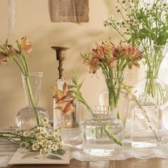 several vases filled with flowers on top of a table