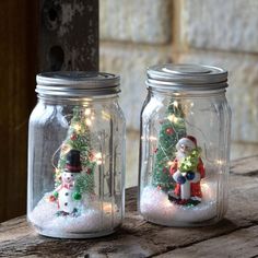 two mason jars filled with snowmen and christmas lights