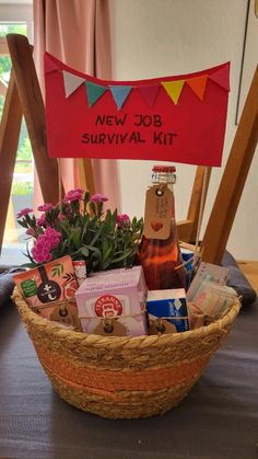 a basket filled with lots of different items on top of a table next to a sign that says new job survival kit