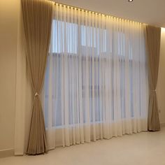 an empty room with curtains and lights on the wall