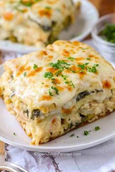 two white plates topped with lasagna casserole and garnished with parsley