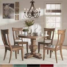 a dining table with four chairs and a chandelier hanging from the ceiling above it