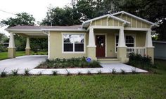 a small house with a red front door and white trim on the side of it