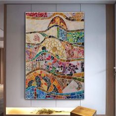 a painting on the wall with many different colors and shapes, including an abstract design