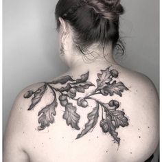 the back of a woman's shoulder with leaves and acorns on it