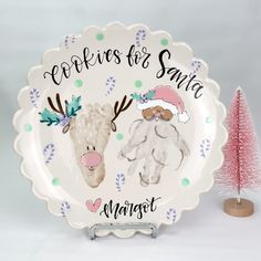 there is a plate with two animals on it next to a small tree and a pink christmas tree