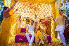 a group of people standing around each other in front of a yellow and white backdrop