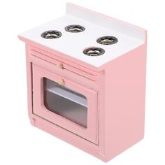 a pink and white toy stove with four burners on the front, one door open