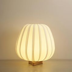 a white lamp sitting on top of a wooden table