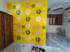 a room that has been painted with flowers on the wall and other items scattered around