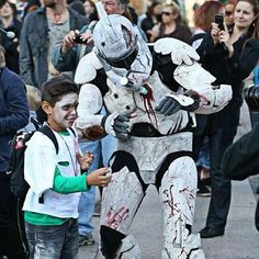 a young boy standing next to a man in a costume