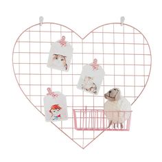 a heart shaped metal rack with pictures hanging from it's sides and a dog inside the basket