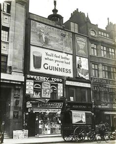 an old black and white photo of a guinness advertisement on the side of a building