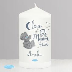 a white candle with a teddy bear on it that says, i love you to the moon and back