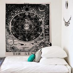 a bed with pillows and a tapestry hanging on the wall