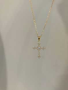 A statement piece doesn't always have to be large, just look at how our cross necklace sparkles! You will surely make a statement at every step you take. Information: ✨ Sterling Silver (925 stamped) | 14K Gold Plated ✨ AAAA grade Cubic Zirconia gemstones ✨ Adjustable length: 16" - 18" ✨ Hypoallergenic ✨ Tarnish resistant ✨ Water friendly Our cross necklace has an splendid level of craftsmanship and attention to detail, from the carefully set gemstones to the high polishing of the metal. Once you see the necklace, there is no doubt about the quality. Plus, the necklace is adjustable. You have the ability to wear it at 16", 17" or 18" allowing you to create various layering possibilities and find your best fit. For centuries, Christians have seen the cross as a symbol of their faith and divi Elegant Cross Necklace For Baptism, Spiritual Cross Pendant Jewelry For Baptism, White Cross Necklace For Baptism, Christian Necklace, Protection Necklace, Small Crosses, Gold Cross, Cross Charms, Jewelry Inspo