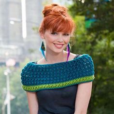 a woman with red hair wearing a blue and green crocheted wrap around her neck