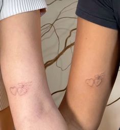 two people with matching tattoos on their legs, one is holding the other's arm