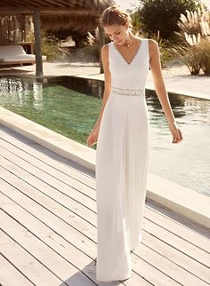 a woman in a white dress standing on a dock