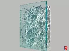 a glass block with water reflecting off it's sides on a gray background,