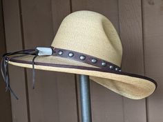 The Elsa Gus Palm hat has a golden hue. The brim is trimmed in brown grosgrain. Distressed leather has been simply decorated and the back has a deer antler bead. The brim measures 4" and the crown is 5 1/2". It's a very soft and comfortable hat. Note: Please allow 3-4 weeks. Brown Curved Brim Hat Bands For Kentucky Derby, Elegant Brown Hat Bands For Rodeo, Rustic Style Hat Bands For Kentucky Derby, Rustic Brimmed Hat Band For Kentucky Derby, Elegant Brown Hat Band For Ranch, High Crown Brown Country Hat, Fitted Brown Straw Hat For Western-themed Events, Brown High Crown Country Hat, Brown Hat For Kentucky Derby And Ranch Events