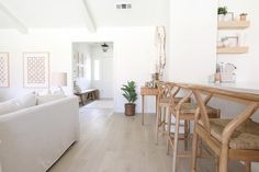 a living room filled with furniture and a wooden table next to a white couch on top of a hard wood floor