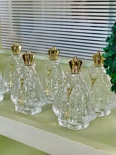 five clear glass perfume bottles sitting on a shelf