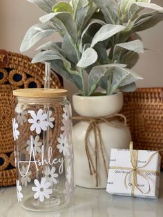 a glass jar sitting on top of a table next to a plant