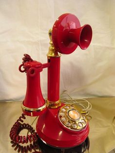 an old fashioned red telephone on a table