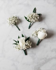 three white roses and baby's breath on a marble surface