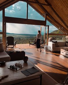 a person standing in a living room looking out at the view from inside a house