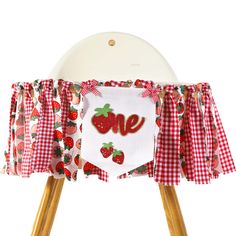 a red and white checkered table cloth with the word love on it, sitting on top of a wooden chair