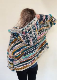 a woman with her back to the camera wrapped in a multicolored shawl