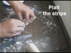 a person is kneading dough on top of a table with a pair of scissors