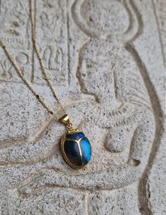 This amazing pendant will make you feel like a living goddess Hand-carved scarab, an ancient reproduction, inlaid with a genuine deep blue shimmering labradorite stone. The gem fits perfectly in the gaps of the beetle. A beautiful tribute to ancient Egypt and to the divine archetypes that we incarnate. In ancient Egypt, the fascinating Scarab Beetle was associated with the solar cycle, as a concept of rebirth and regeneration. The God Khepri was rising the sun every day before rolling it above the horizon, then carried it through the other world after sunset, just to renew it, again, the next morning. The decisive symbolism came from the association of the dung ball to the sun: the scarab rolling his dung ball provided an explanation of the sun's movement in the sky. Powerful amulet used a Artisan Ankh Jewelry For Gift, Beetle Jewelry, Scarab Jewelry, Ancient Egyptian Jewelry, The Beetle, Egyptian Scarab, Scarab Beetle, Egyptian Jewelry, Egyptian Revival