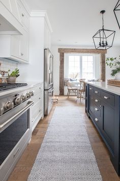 a kitchen with an oven, stove and dining room table in the backround