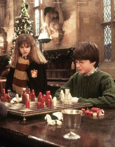 the harry potters chess game is being played in front of a christmas tree and other people