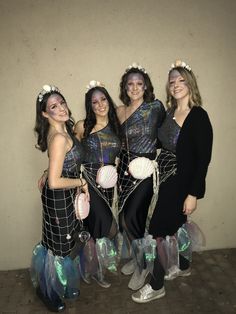 four women dressed in costumes posing for a photo