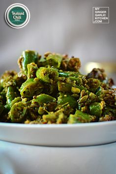 a white bowl filled with cooked green peppers