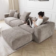 a woman sitting on a couch reading a book