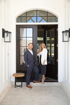 a man and woman standing in front of a door