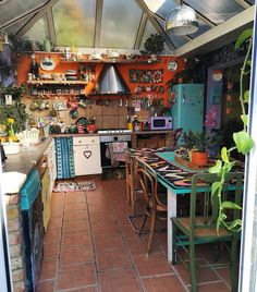 a kitchen filled with lots of clutter and furniture next to a stove top oven