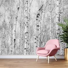 a pink chair sitting in front of a wall with white birch trees painted on it