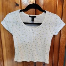 Cropped Floral Tee. New With Tags! Has Pearly Buttons. Ribbed 100% Cotton T-Shirt With Blue Floral Pattern. Fun 90s Femme Style! It's Very Soft And Stretchy. The Buttons Make It Super Cute. Perfect Little Delicate Floral Top To Pair With Jeans And Looks Great With A Leather Jacket (See Pictures And Check My Closet For The Listing!) Floral Baby Tee Floral Cotton T-Shirt Knit Floral Pattern Cropped Shirt Button Up Floral Cotton T-Shirt Fitted Cotton Tops For Spring, Fitted Cotton Crop Top Shirt, Casual Fitted Floral Print T-shirt, Fitted Floral Print Casual T-shirt, Floral Print Cotton Crop Top, Casual Summer Crop Top Shirt, Casual Crop Top Shirt For Summer, Fitted T-shirt For Spring, Summer Cotton Crop Top Shirt