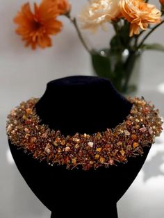 This stunning handmade necklace features an intricate design adorned with an array of delicate beads and natural stones in rich brown and amber tones. The wide band showcases a mix of earthy hues, giving it a luxurious and textured look. Natural stones in this necklace are known for their grounding energy, promoting stability and inner strength. Perfect for adding a touch of elegance and positive energy to any outfit, this necklace is both stylish and meaningful. Features: Handmade with high-quality beads and natural stones Intricate beaded design in shades of brown and amber Wide band for a bold and fashionable statement Natural stones represents stability, inner strength, and grounding energy Perfect accessory for special occasions or everyday wear Makes a thoughtful gift for a loved one Luxury Handmade Beaded Necklace As Gift, Luxury Handmade Beaded Necklace For Gift, Brown Faceted Beads Jewelry For Party, Luxury Handmade Brown Necklaces, Luxury Handmade Brown Necklace, Brown Choker Necklace For Party, Brown Beaded Jewelry Gift, Brown Faceted Beads Necklace For Party, Brown Jewelry With Colorful Beads As A Gift