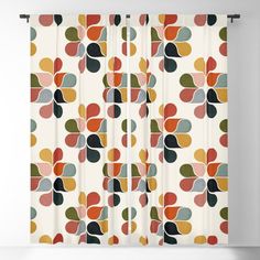 a curtain with colorful circles on it in white and orange colors, hanging from a wall