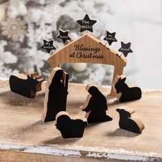 the nativity scene is made out of wood and has black silhouettes on it