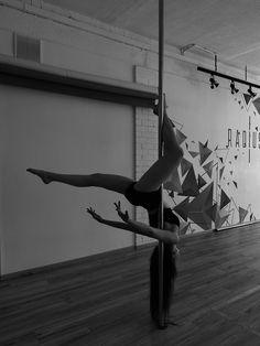 the woman is practicing her acrobatic skills in the room with wood floors